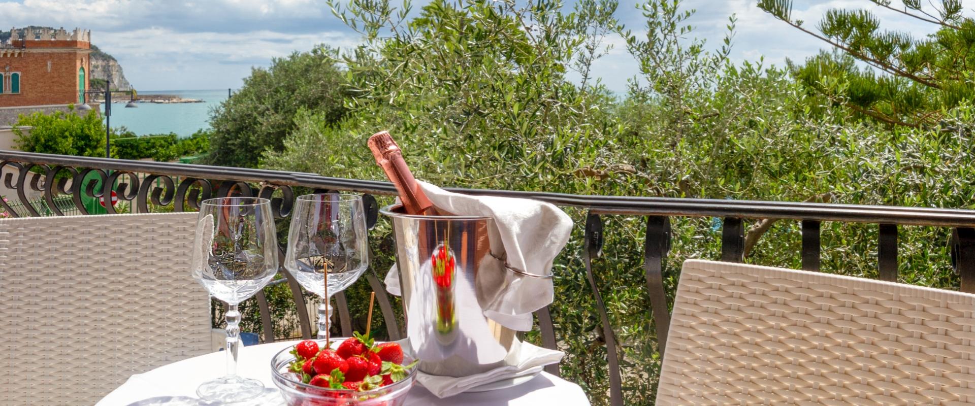 Vista sul mare con tavolo apparecchiato, champagne e fragole.