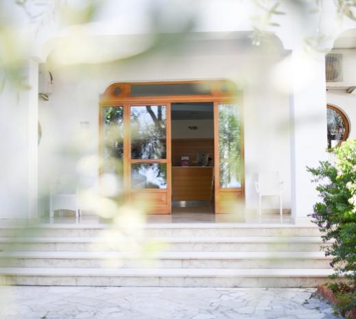 Ingresso di un edificio con porte in legno e gradini di marmo.