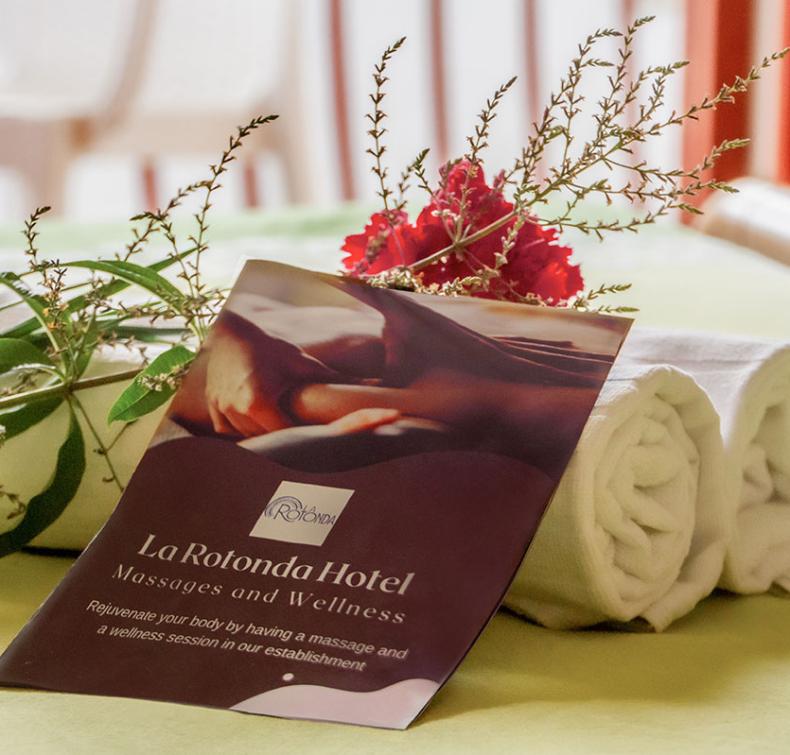 Brochure di massaggi e benessere dell'Hotel La Rotonda con asciugamani e decorazioni floreali.